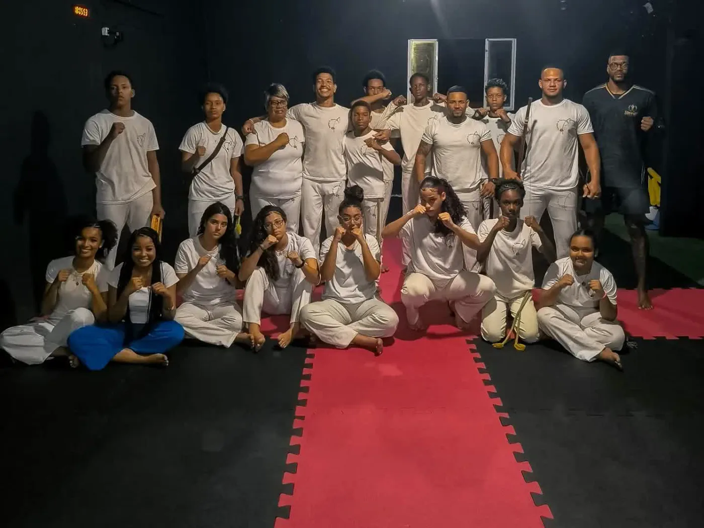 Turma de Capoeira uniformizada no tatame do CT com o professor William Santiago